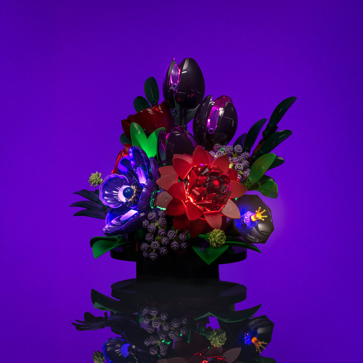 Faretto verde che illumina steli e foglie del LEGO® Botanicals Composizione di fiori scuri