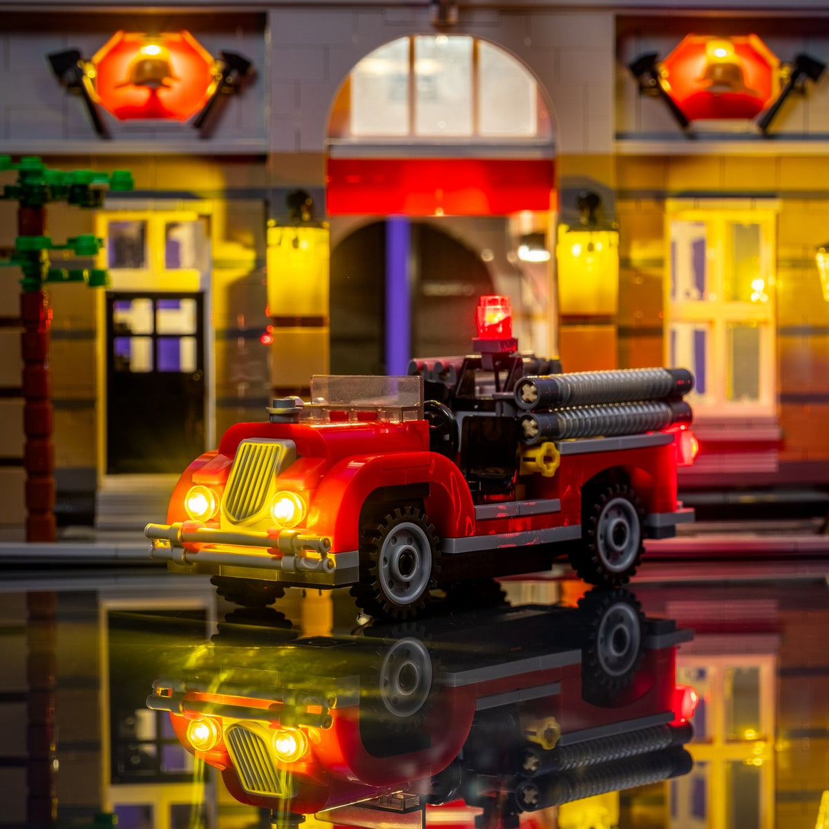 Beleuchtetes Feuerwehrauto vor der hell ausgeleuchteten LEGO® Feuerwache