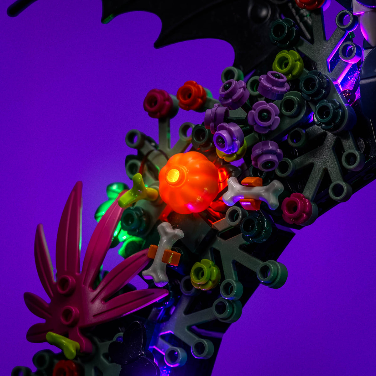 Éclairage orange, vert et violet autour des citrouilles de LEGO® La couronne d’Halloween